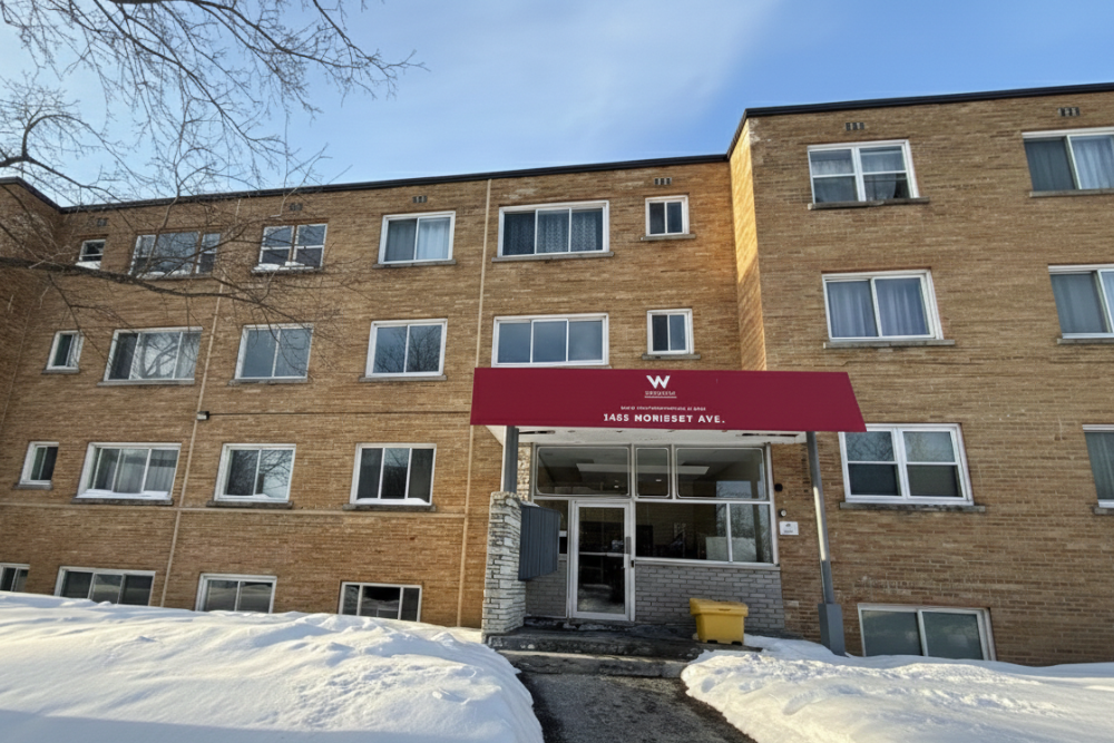 Exterior view of 1455 Morisset Avenue condominium building in Ottawa showing brick facade and main entrance in winter, listed by Anna Alemi.