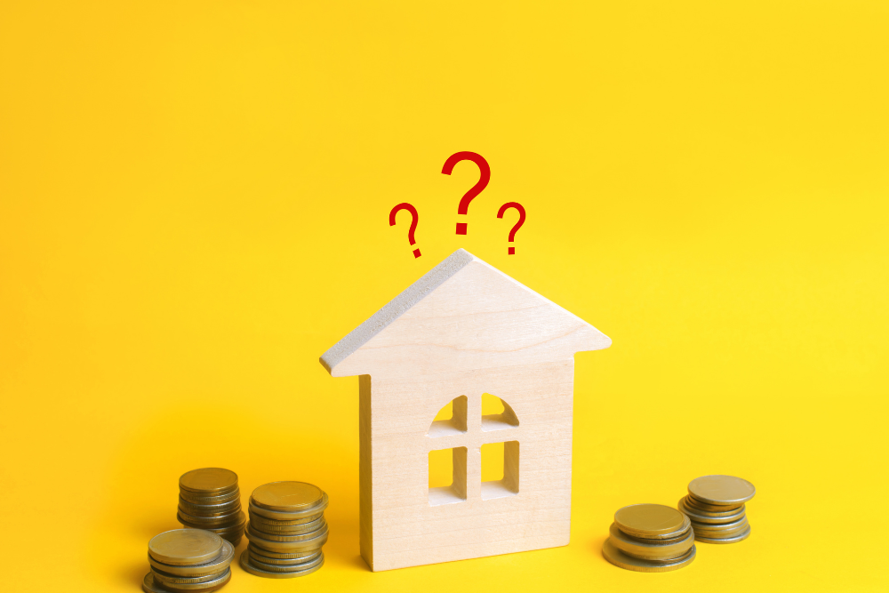 Concept image representing uncertainty in the housing market in Ontario Canada with a house model, coins, and question marks.