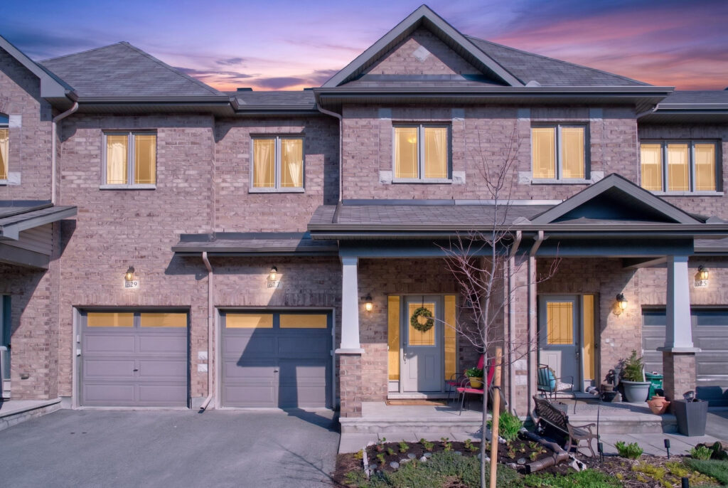 Front exterior of a modern detached family home on Via Campanale with attached garage, covered entryway, and landscaped front yard at dusk.