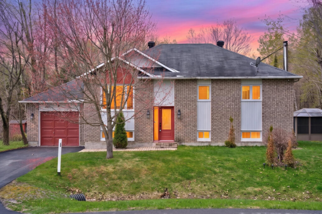 Modern detached family home in Forest Hill with private backyard oasis, forest views, and spacious driveway at sunset.