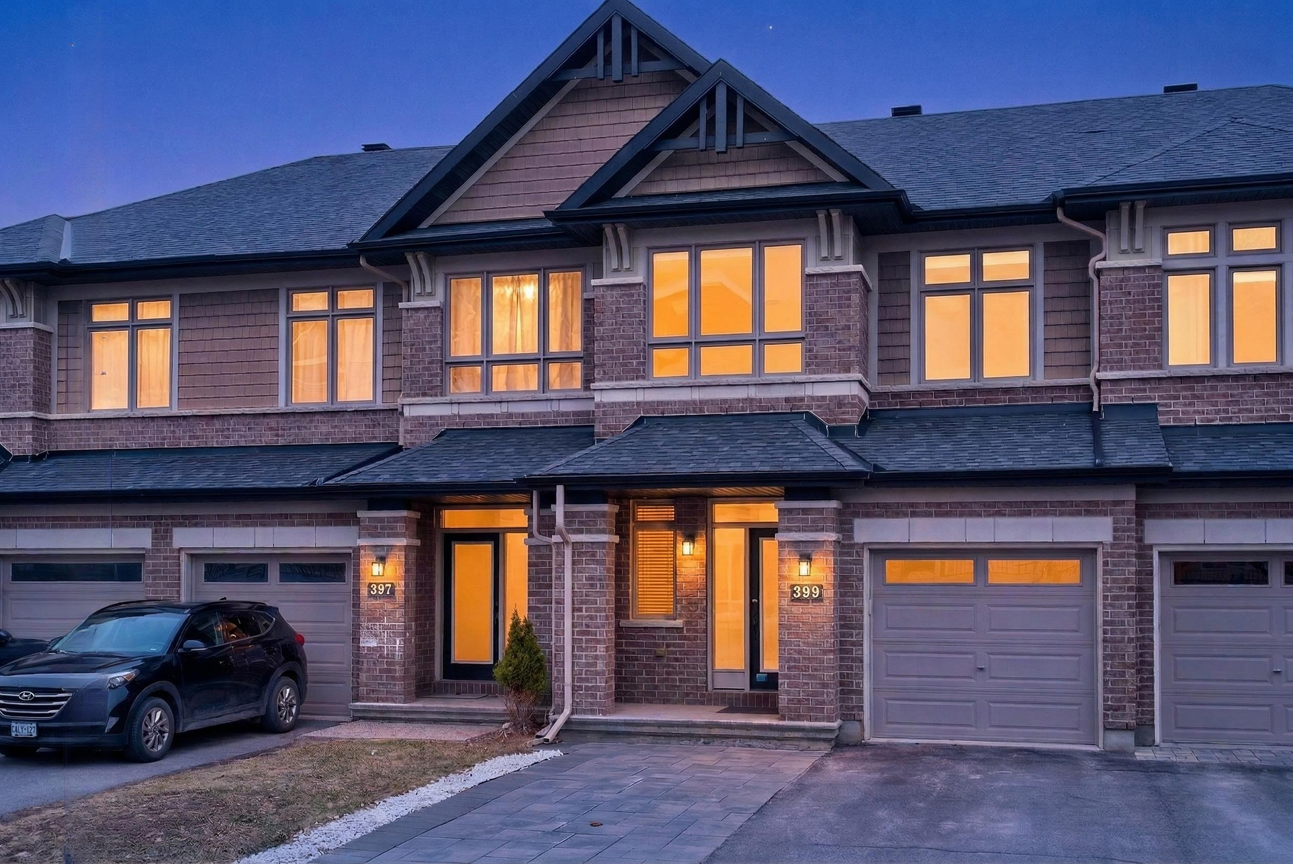 30 Peacock Crescent townhouse in Barrhaven with brick exterior, attached garage, and warm evening lighting in a family-friendly Ottawa neighbourhood.